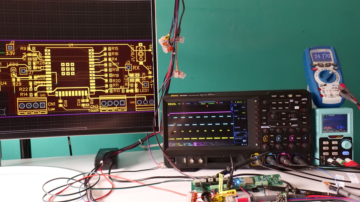 Electronics test bench with oscilloscope, multimeter and PCB
