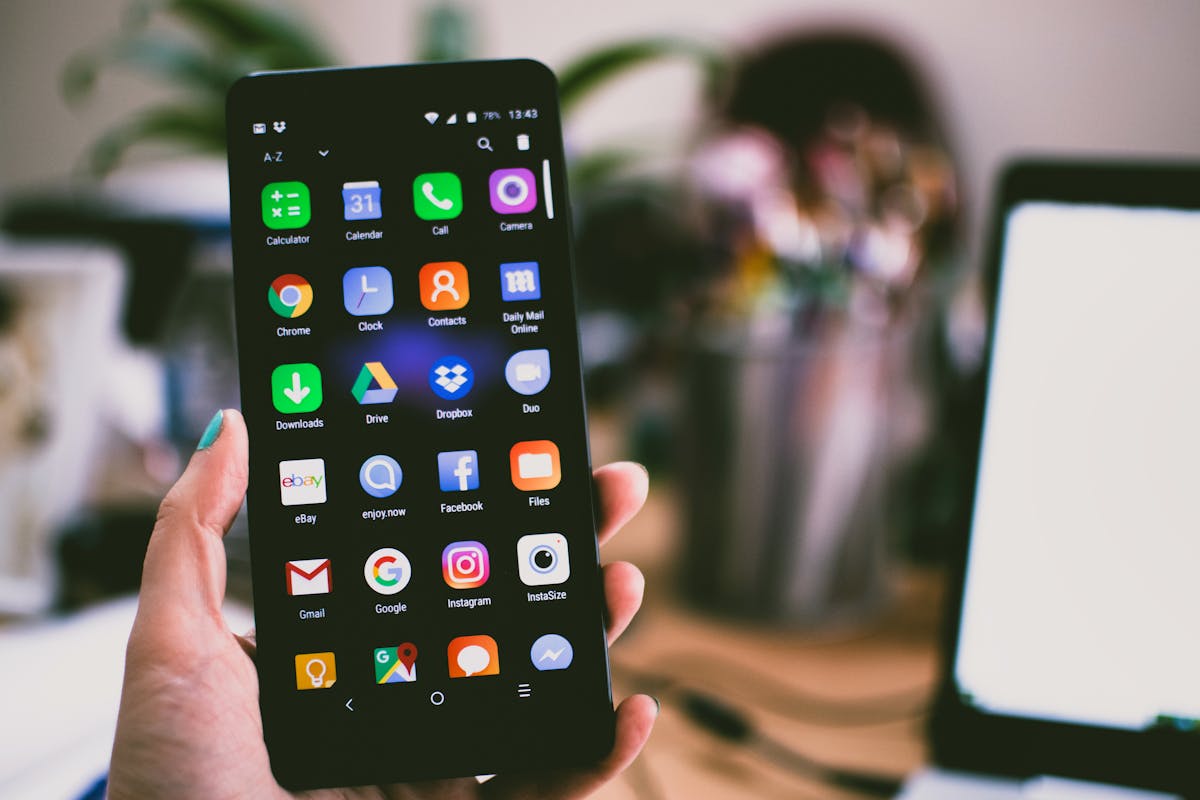 Hand holding Android smartphone, mobile app testing on real device